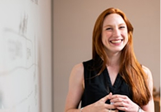 Woman laughing near whiteboard